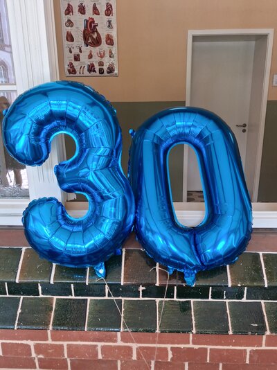 Blaue Luftballons bilden die Zahl Dreißig